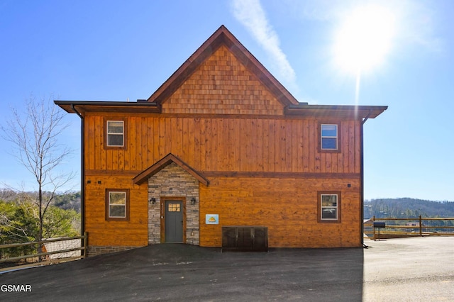 chalet / cabin with stone siding and fence