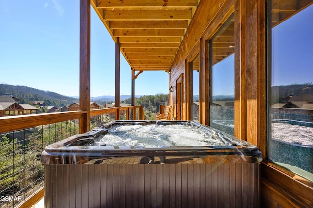 deck with a mountain view and a hot tub