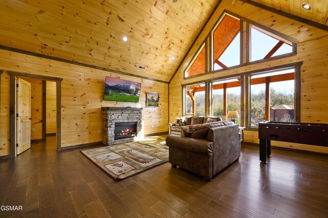 living room with high vaulted ceiling, dark wood-style flooring, a fireplace, and wood walls