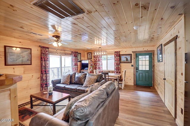 living room with wood ceiling, a healthy amount of sunlight, light hardwood / wood-style flooring, and wood walls