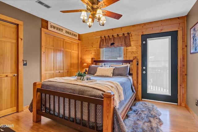 3501 Ginseng Way, Pigeon Forge, TN 37862 - bedroom featuring light wood finished floors, a closet, wooden walls, and ceiling fan