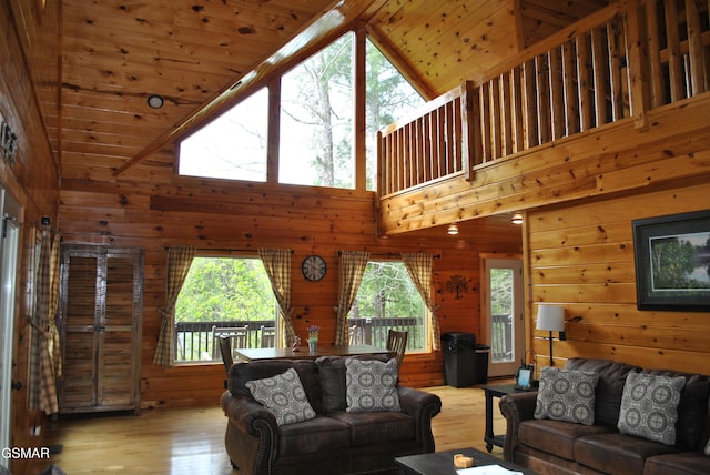 living area featuring wood-type flooring, a wealth of natural light, and wood walls