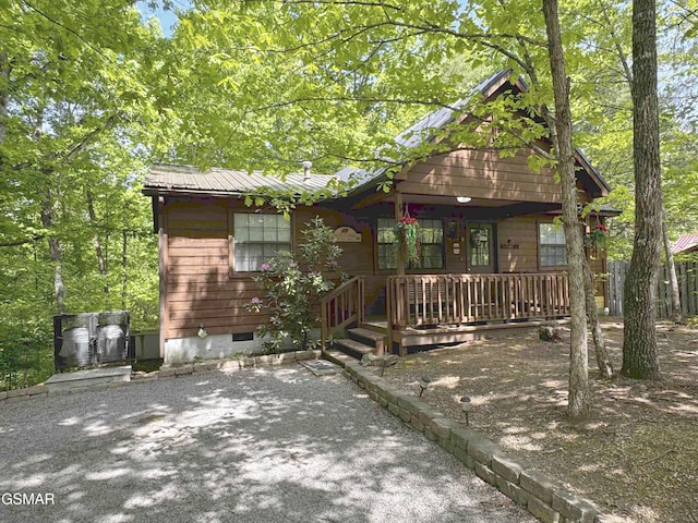 rustic home featuring covered porch, crawl space, and metal roof