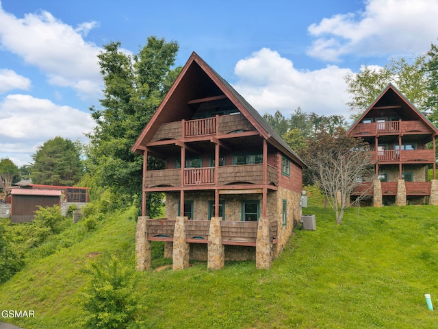 1619 Jed Trl, Sevierville, TN 37862 - back of property with a balcony, cooling unit, a lawn, and stone siding