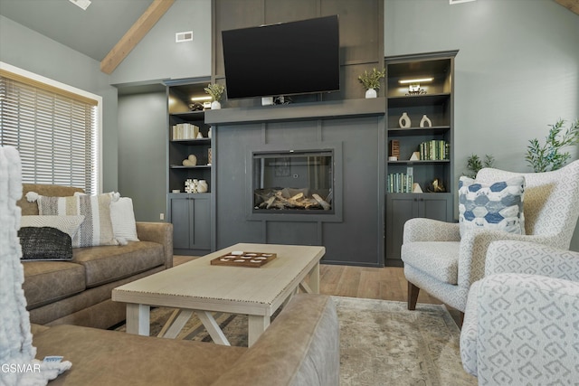 living area featuring visible vents, a fireplace, lofted ceiling with beams, and wood finished floors