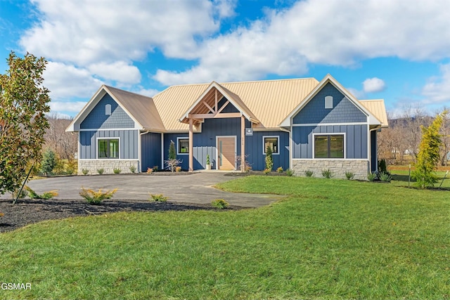 craftsman house featuring a front lawn, a garage, stone siding, aphalt driveway, and board and batten siding