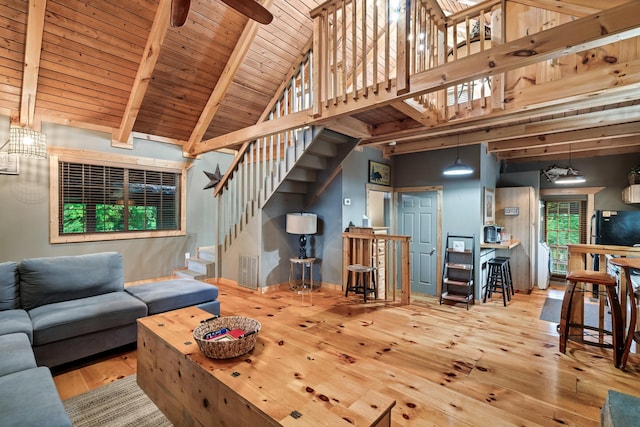 living area featuring beam ceiling, stairway, high vaulted ceiling, wooden ceiling, and hardwood / wood-style floors