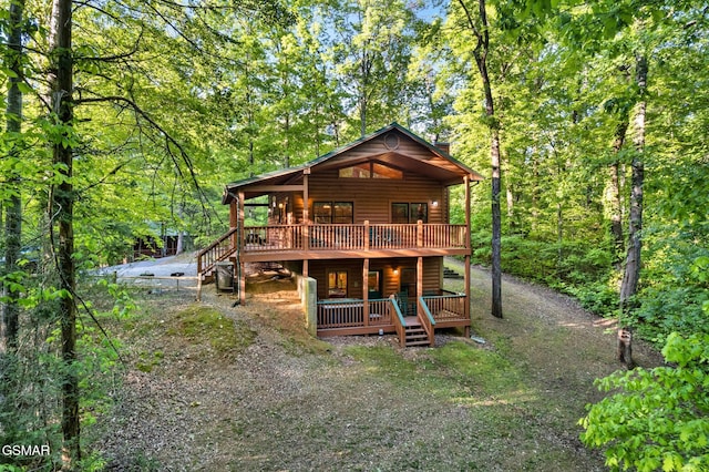 3828 Saddle Brook Way, Sevierville, TN 37862 - rear view of property featuring a forest view, log veneer siding, a wooden deck, and gravel driveway
