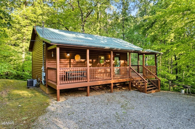 3828 Saddle Brook Way, Sevierville, TN 37862 - rustic home with cooling unit, a forest view, faux log siding, and metal roof