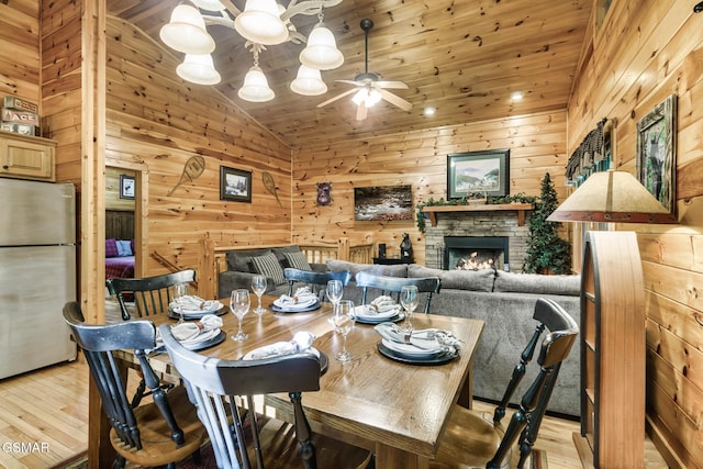 3828 Saddle Brook Way, Sevierville, TN 37862 - dining room with lofted ceiling, light wood finished floors, wood walls, and ceiling fan with notable chandelier