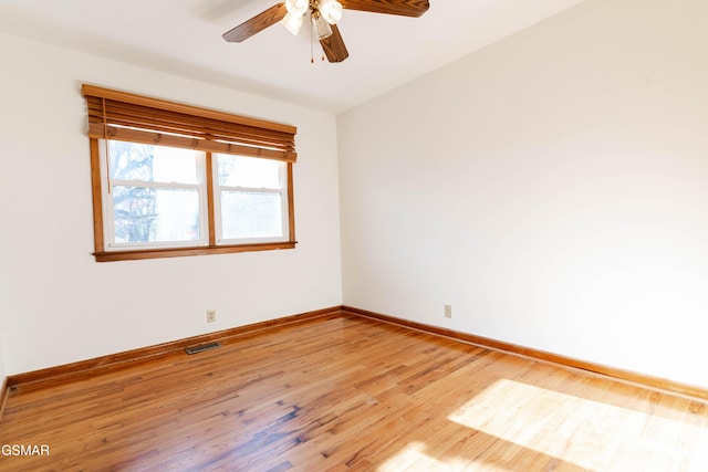 empty room with baseboards, ceiling fan, light wood finished floors, and visible vents