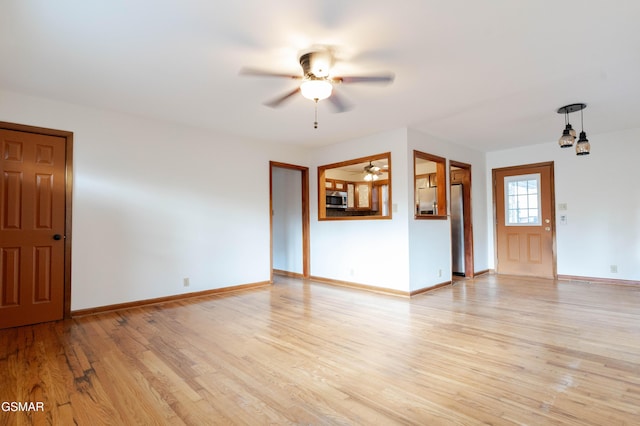 unfurnished living room with ceiling fan, baseboards, and light wood finished floors