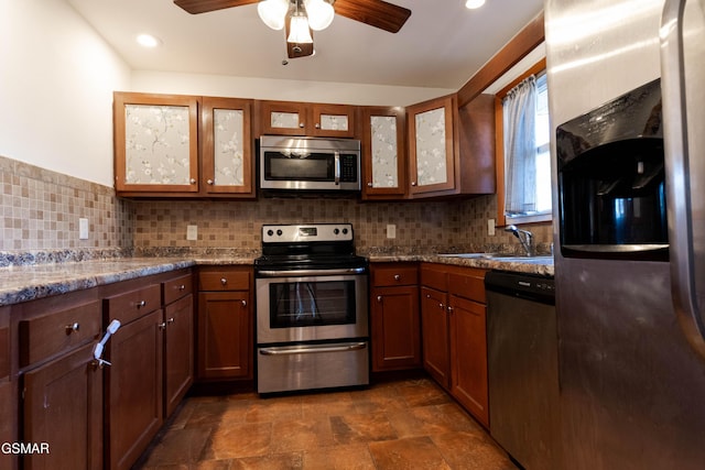 kitchen featuring a ceiling fan, appliances with stainless steel finishes, a sink, and tasteful backsplash