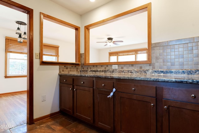 bathroom with baseboards, decorative backsplash, ceiling fan, and a wealth of natural light