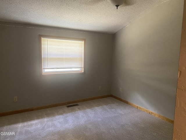 empty room with carpet and a textured ceiling