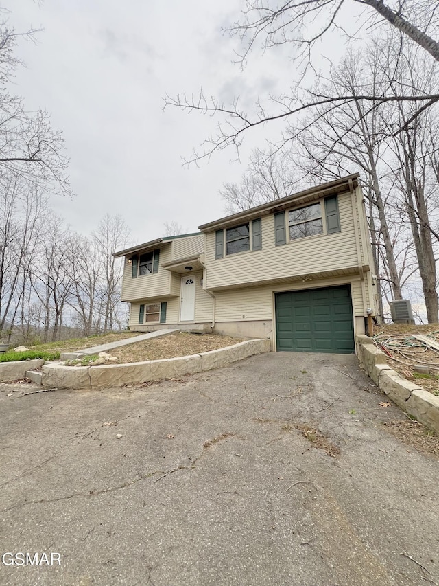 split foyer home featuring aphalt driveway and a garage