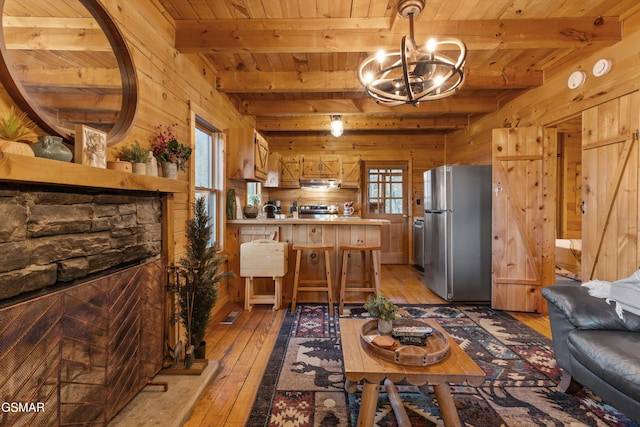 interior space featuring plenty of natural light, light wood-type flooring, and wooden walls