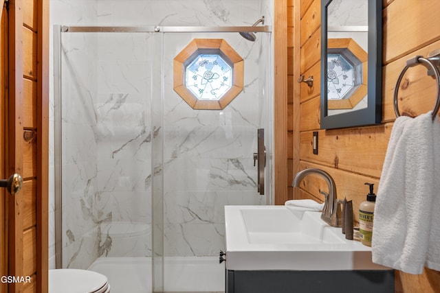 full bathroom featuring toilet, a marble finish shower, and vanity