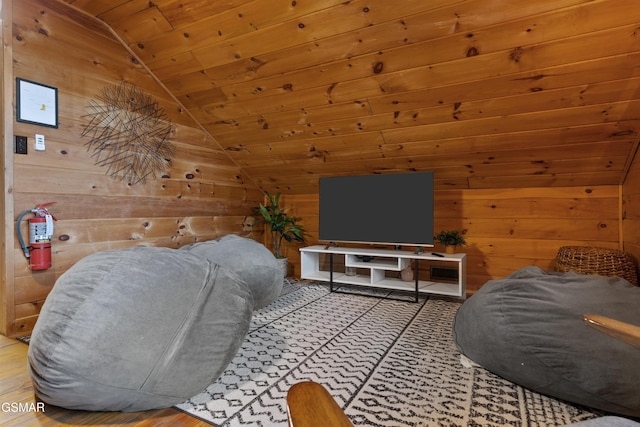 living area featuring lofted ceiling, wood ceiling, and wooden walls