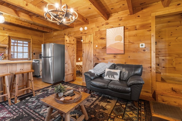 living area featuring wood ceiling, beam ceiling, a notable chandelier, and wood walls