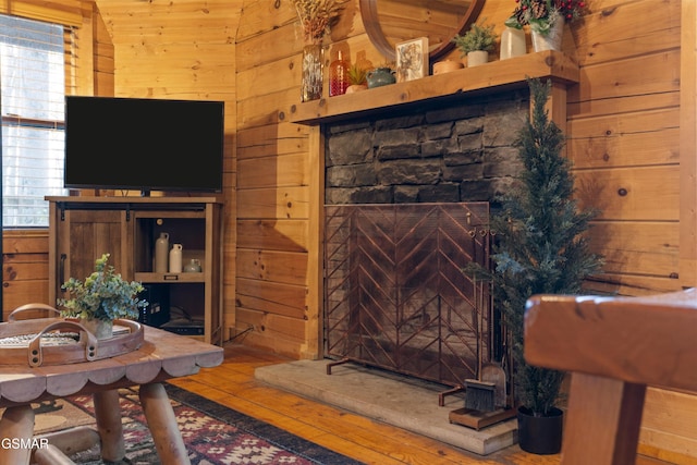 living room with a healthy amount of sunlight, wooden walls, and hardwood / wood-style flooring