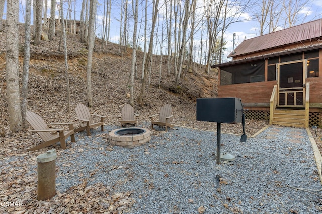 view of yard featuring a sunroom and a fire pit