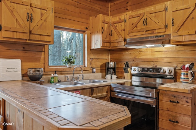 kitchen with tile counters, a sink, stainless steel range with electric stovetop, and under cabinet range hood