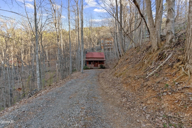 view of front of house featuring driveway and a wooded view