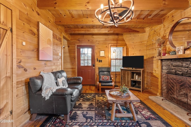 living room with wood-type flooring, wooden walls, and beam ceiling