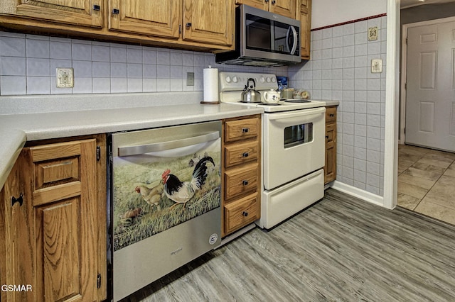 kitchen featuring decorative backsplash, stainless steel appliances, and light hardwood / wood-style flooring