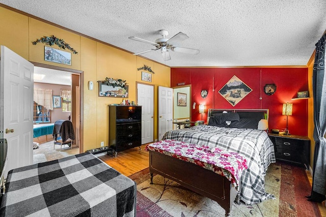 bedroom with ceiling fan, hardwood / wood-style floors, crown molding, and a textured ceiling