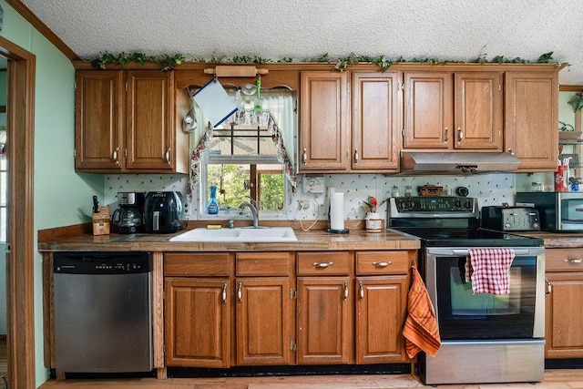 kitchen with a textured ceiling, sink, and appliances with stainless steel finishes