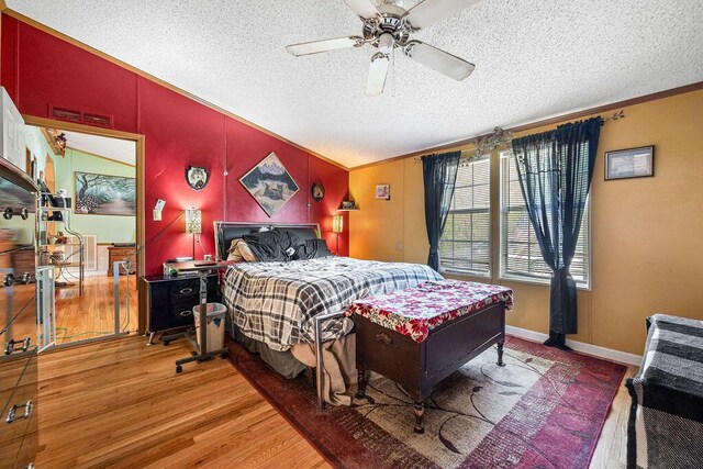 bedroom with ceiling fan, crown molding, wood-type flooring, and a textured ceiling