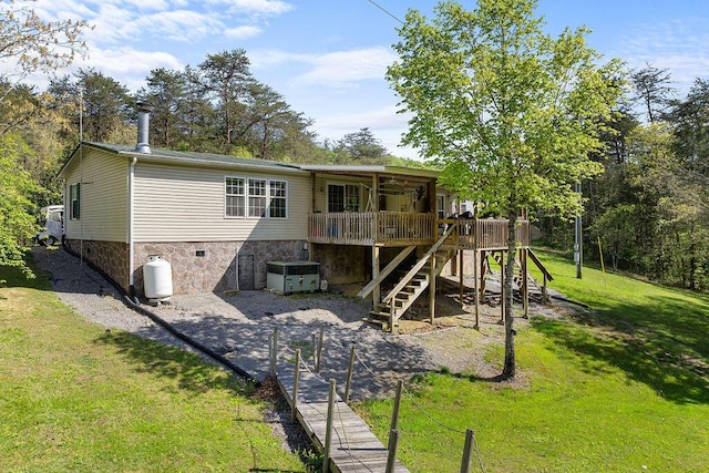 back of house featuring a lawn and a deck