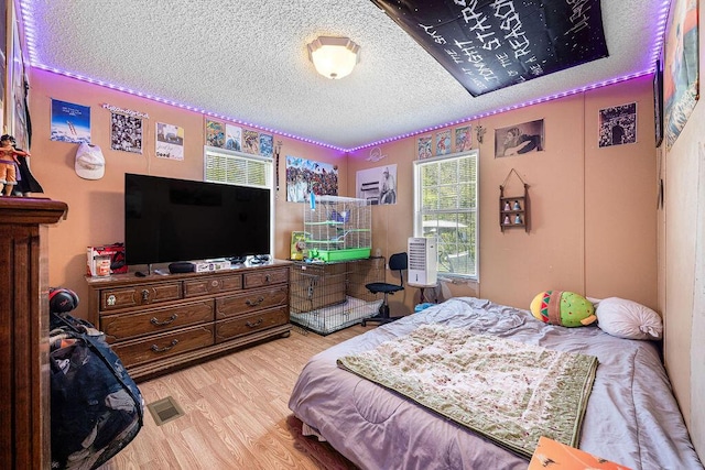 bedroom featuring hardwood / wood-style flooring and a textured ceiling