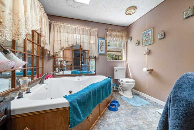 bathroom featuring a bath, a textured ceiling, and toilet