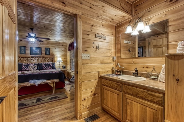 bathroom featuring vanity, hardwood / wood-style floors, wooden walls, and wooden ceiling