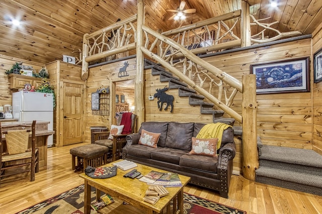 living room with wood walls, hardwood / wood-style floors, high vaulted ceiling, and wood ceiling