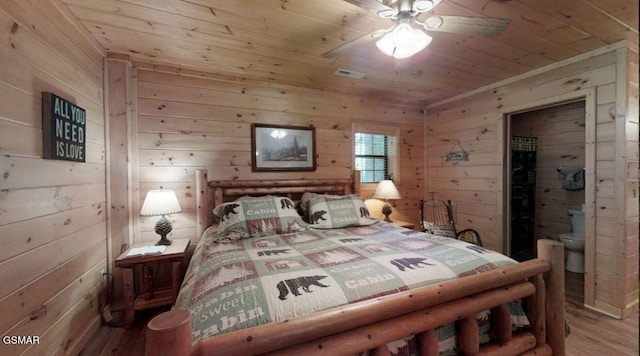 bedroom featuring ceiling fan, wooden walls, and wood ceiling