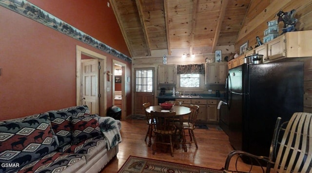 dining room featuring hardwood / wood-style floors, vaulted ceiling with beams, wood ceiling, and sink