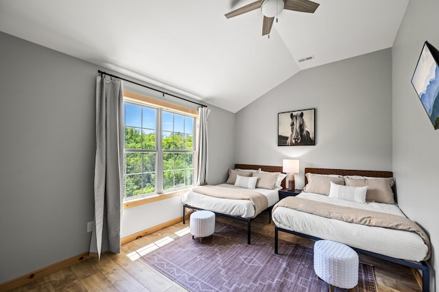 bedroom with ceiling fan, wood-type flooring, and vaulted ceiling