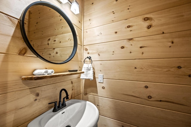 bathroom with sink and wooden walls