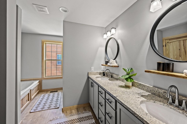 bathroom with a tub, vanity, and hardwood / wood-style flooring