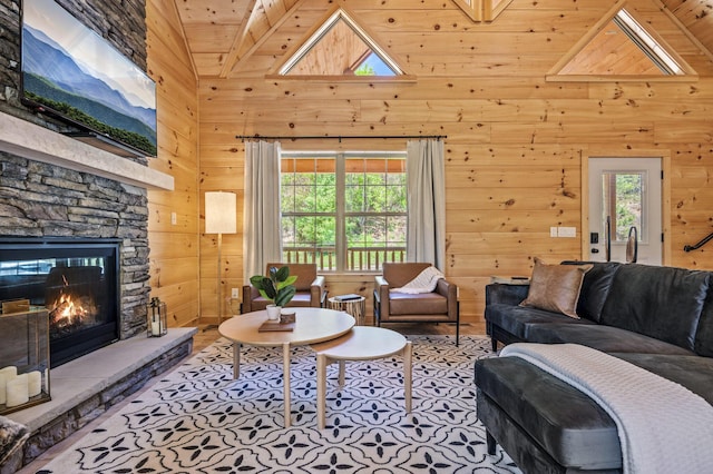 living room with a stone fireplace, high vaulted ceiling, and wooden ceiling