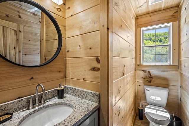 bathroom with wooden walls, vanity, wood ceiling, and toilet