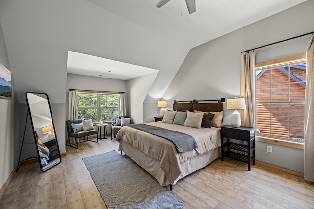 bedroom featuring light hardwood / wood-style floors, vaulted ceiling, and ceiling fan