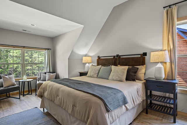 bedroom featuring lofted ceiling and light wood-type flooring