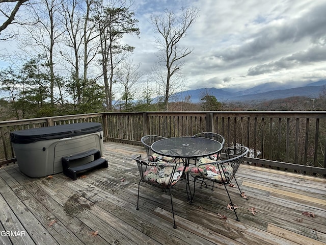 wooden deck featuring a mountain view and a hot tub