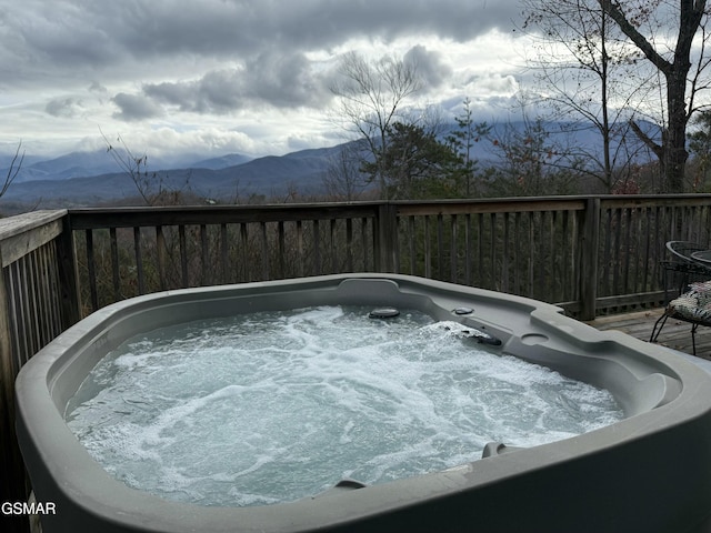 view of swimming pool featuring a deck with mountain view and a hot tub