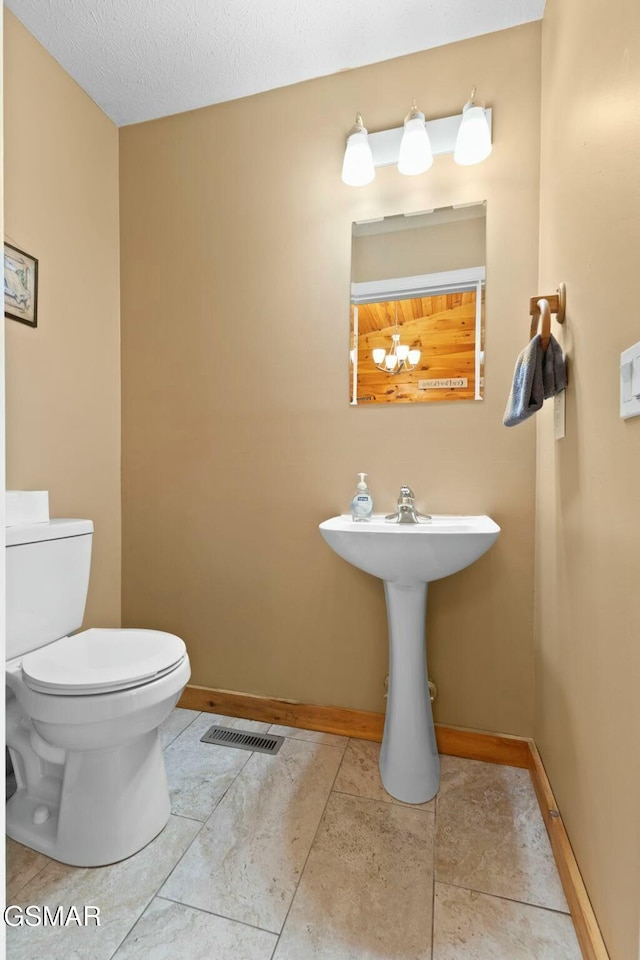 bathroom featuring a textured ceiling and toilet